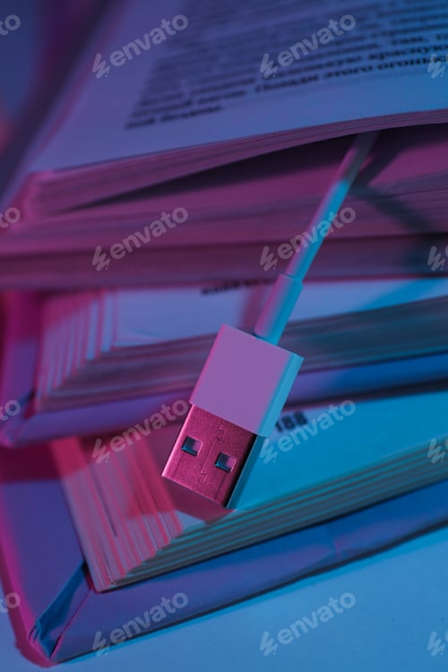 Preview: Open books and USB cord on gray background, close up
