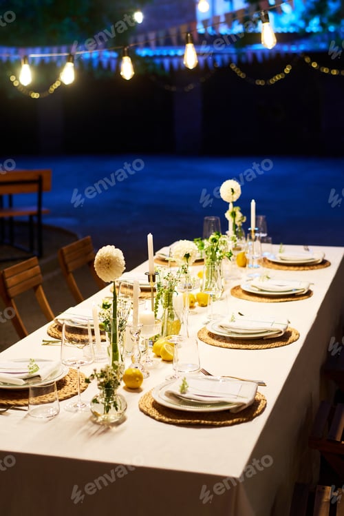 Preview: Long table covered with white tablecloth with plates and decorations