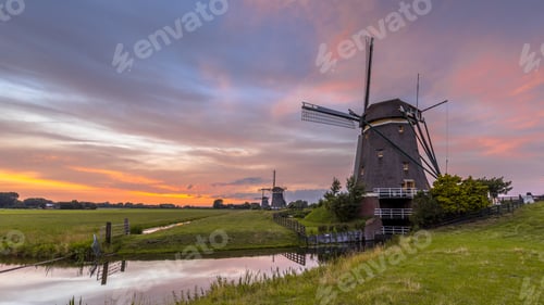 Preview: Three windmills in a row under beautiful sunset