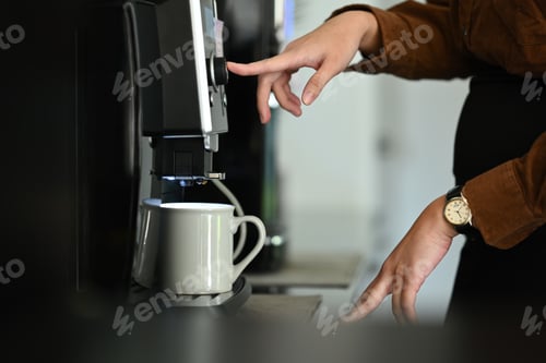 Preview: Closeup business woman using coffee machine in the office.