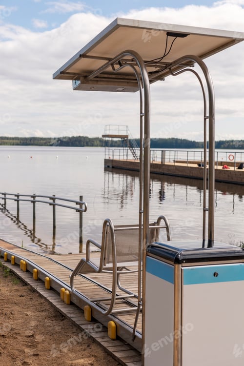 Preview: A special sliding chair is positioned on a wooden ramp leading to the lake