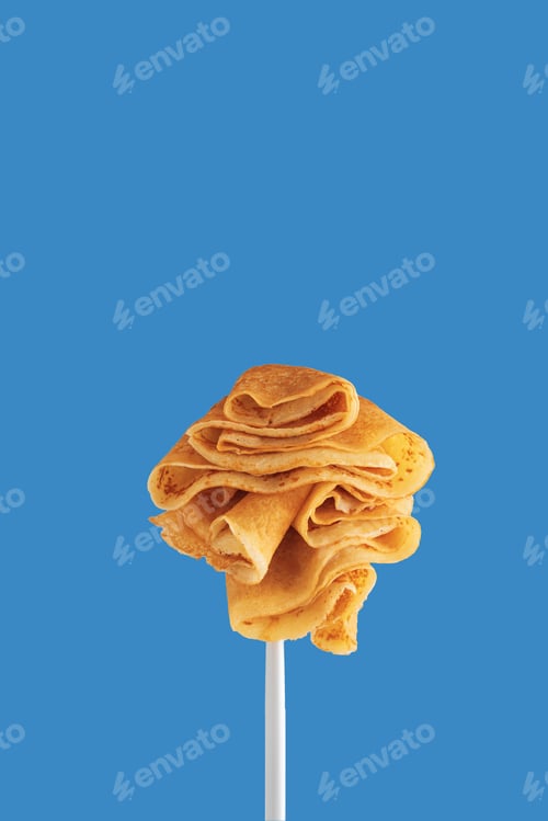 Preview: Golden pancakes on a fork against a vibrant blue background.