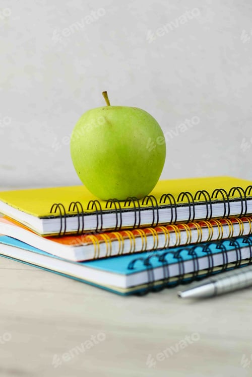Preview: black to school concept with apple on notepad on table.