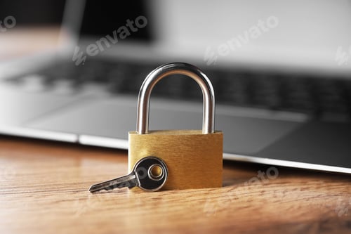 Preview: Cyber safety. Metal padlock, key and laptop on wooden table, closeup