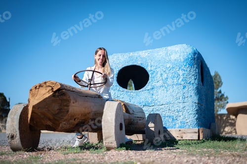 Preview: A Young girl riding a automobile made out of wood