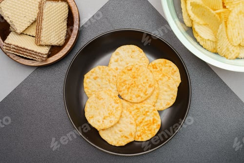 Preview: Flat lay of snack, Crispy potato chip and wafer in various containers on gray background