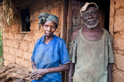 Preview: Elderly couple standing by their traditional mudbrick home.