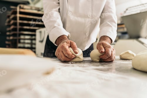 Preview: Baker kneading dough in a bakery.
