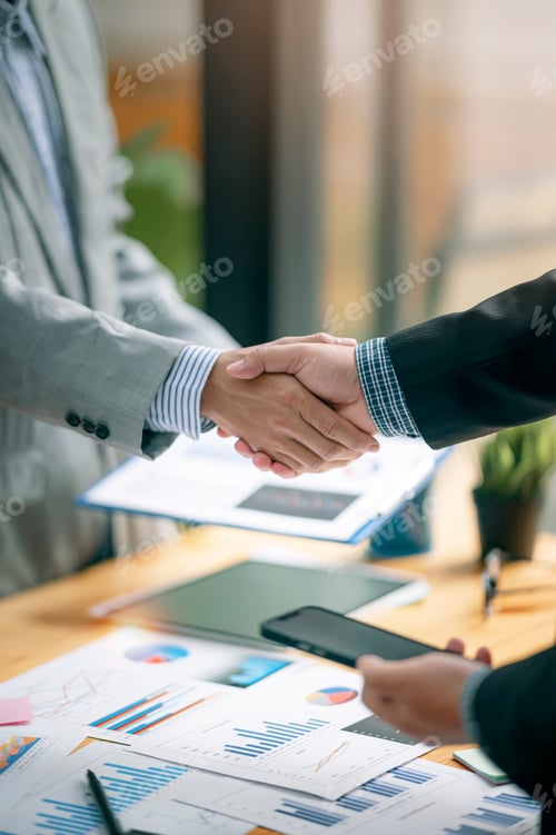 Preview: Two Businessman handshake for teamwork of business merger and acquisition at office.