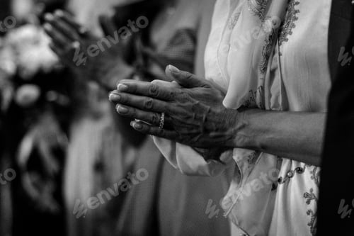 Preview: Closeup grayscale shot of woman's hands in a pose of pray in the church, against blur background