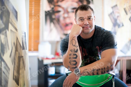 Preview: Portrait of mature male artist sitting in studio