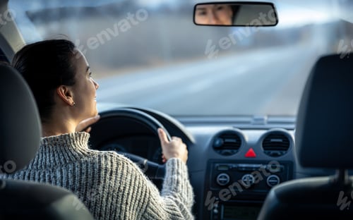 Preview: Happy young woman drives a car, inside view.