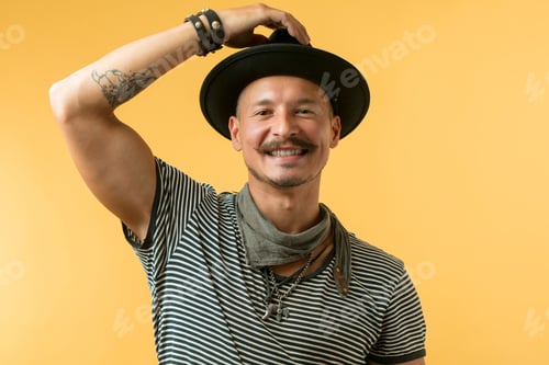 Preview: Happy man with moustache wearing hat isolated over yellow background.