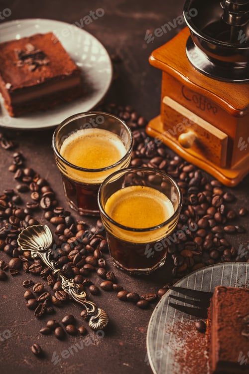 Preview: Two espresso coffee mugs with piece of chocolate cake on brown background