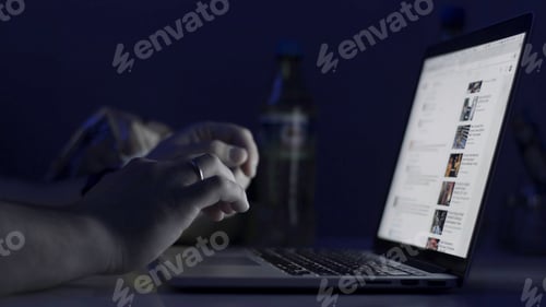 Preview: A man's hands working on the laptop at night. The laptop is on the table. View from the top. Close