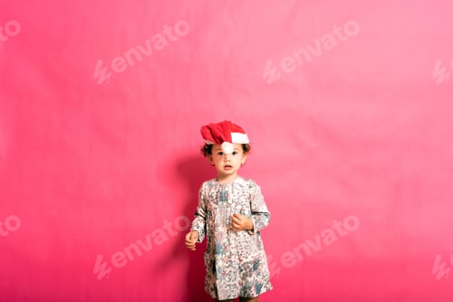 Preview: Two-year-old baby with a misplaced santa hat and funny look