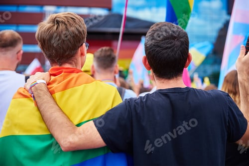 Preview: Two male friends with rainbow flags on pride demonstration