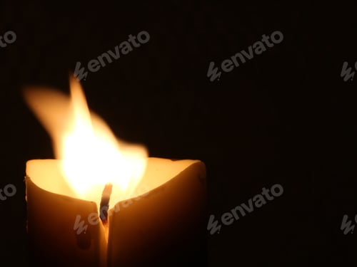 Preview: Burning Candle Against Dark Background With Flame Blowing - Photograph Of A Light Colored Candle