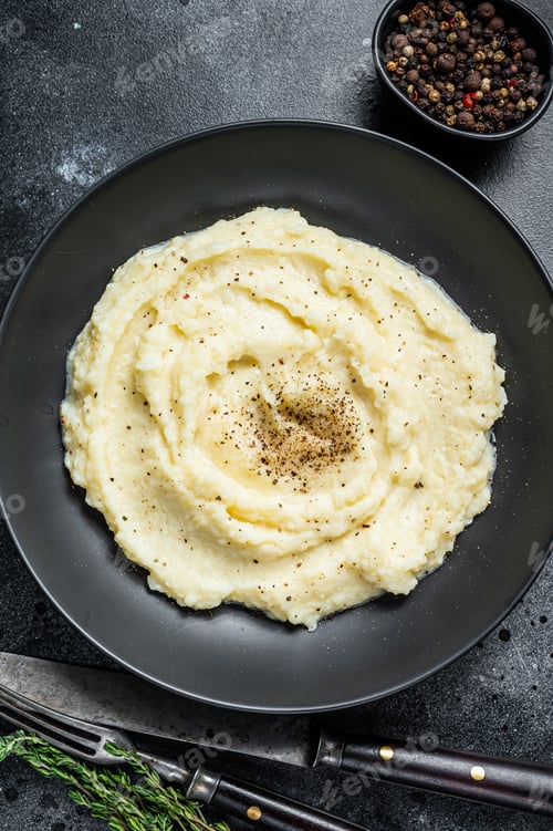 Preview: Potato puree, Mashed potatoes in a plate with herbs. Black background. Top view