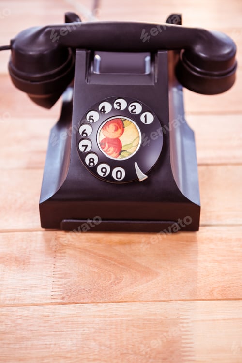 Preview: Close up view of a old phone on wooden desk
