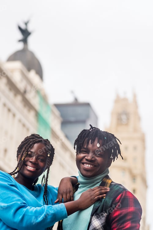 Preview: Black couple in love, in the city. Looking at camera smiling. Selective focus.