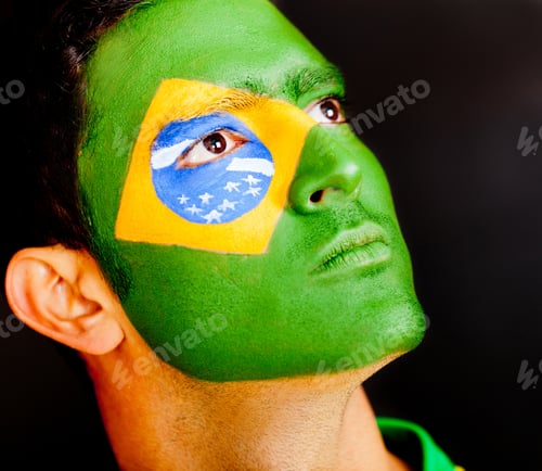 Preview: Proud Brazilian Male With Flag Painted On His Face - Isolated Over Black