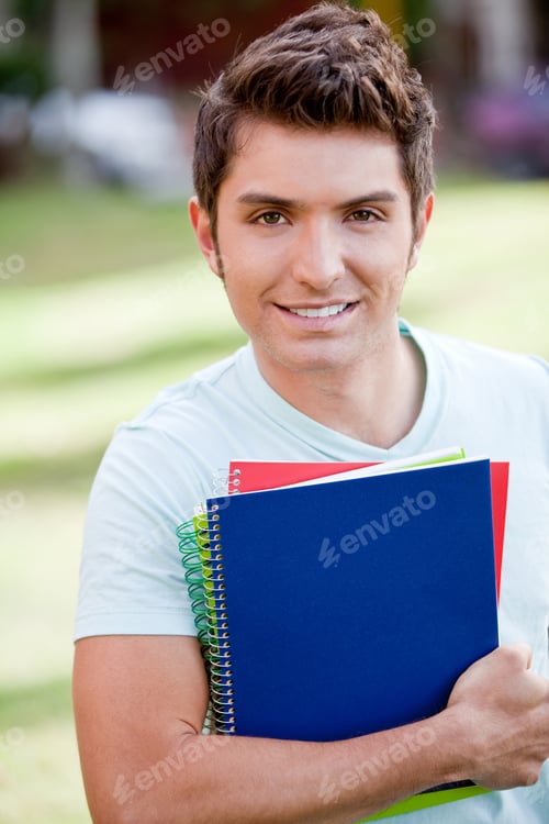 Preview: Male Student With A Notebook Outdoors And Smiling