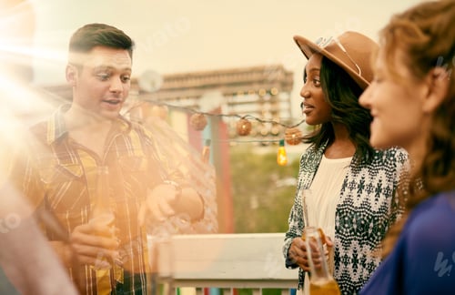 Preview: Multi-Ethnic Millenial Group Of Friends Partying And Enjoying A Beer On Rooftop Terrasse At Sunset