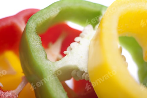Preview: Red Yellow And Green Peppers Sliced On An Isolated White Background