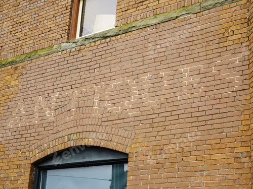 Preview: Exterior Wall Of Old Brick Building With "Antiques" In Faint Capital Letters In A Commercial