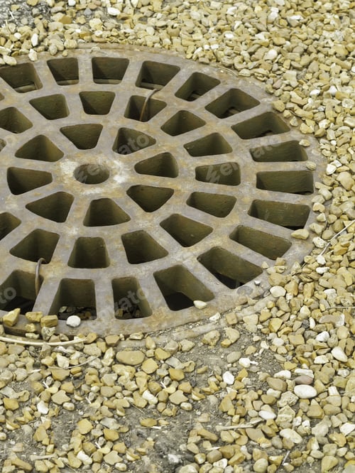 Preview: Round Storm Drain, Off Center, Surrounded By Garden Stones