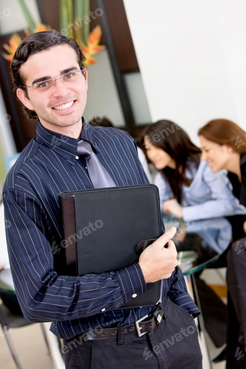 Preview: Confident Business Man Holding A Portfolio With His Team Behind