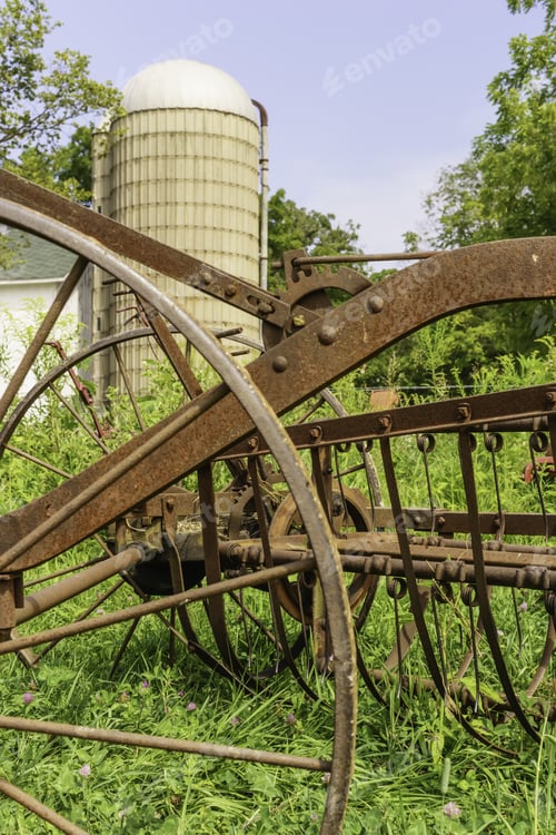 Preview: Rural Bygones At A Glance: Vintage Farm Machinery Stands Rusting In Grass Near Silo On Public