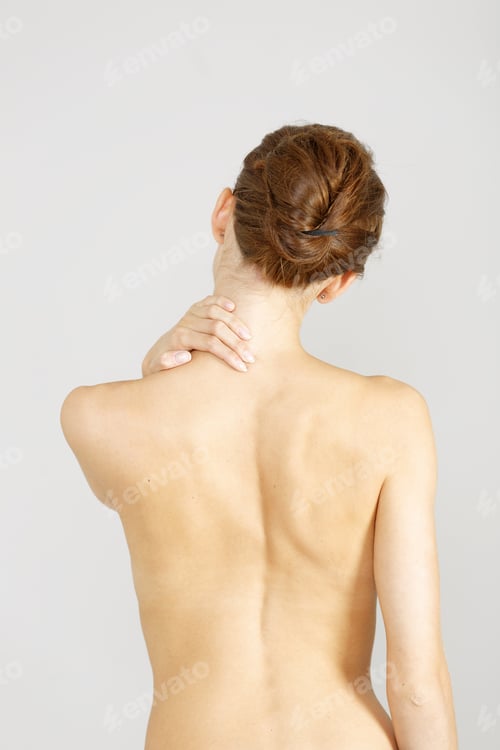Preview: Young Woman Facing Away Massaging Her Neck From An Ache Or Pain