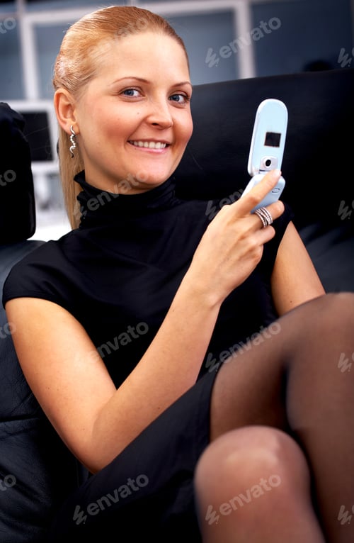 Preview: Business Woman On The Phone In An Office Smiling And Facing The Camera