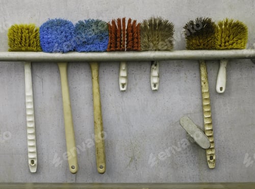 Preview: Reality Check: Seven Scrub Brushes Hanging In A Row Against Bulkhead Of A Commercial Fishing Vessel