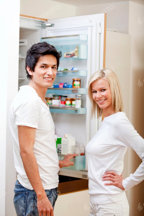 Preview: Couple At Home Looking Inside The Fridge And Smiling