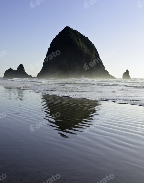 Preview: Haystack Rock, Tallest Sea Stack In Cannon Beach, Oregon, Reflected On Wet Surface Of Sandy Beach