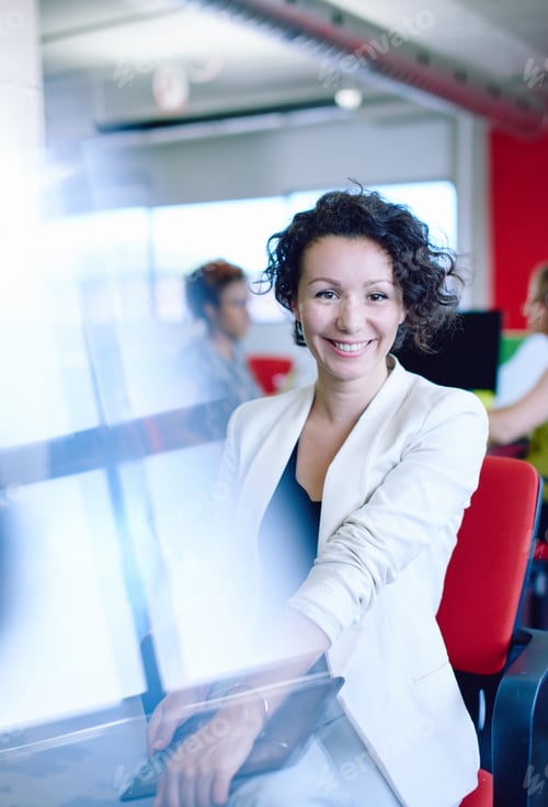 Preview: Confident Female Designer Working On A Digital Tablet In Red Creative Office Space