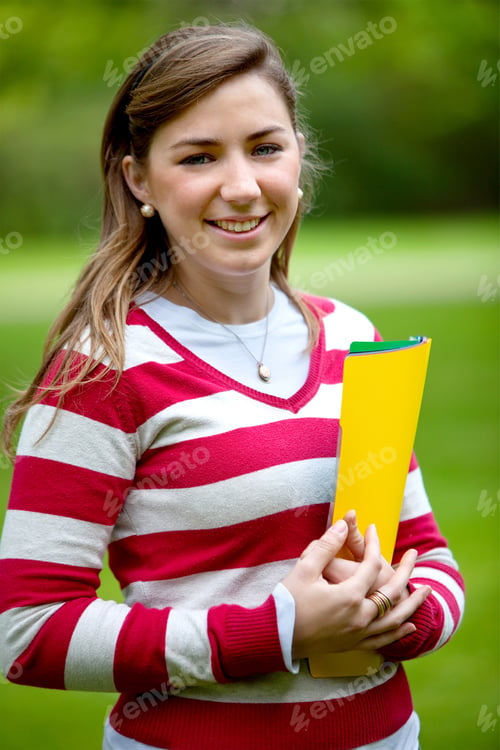 Preview: Beautiful Female Student Smiling With Folders Outdoors