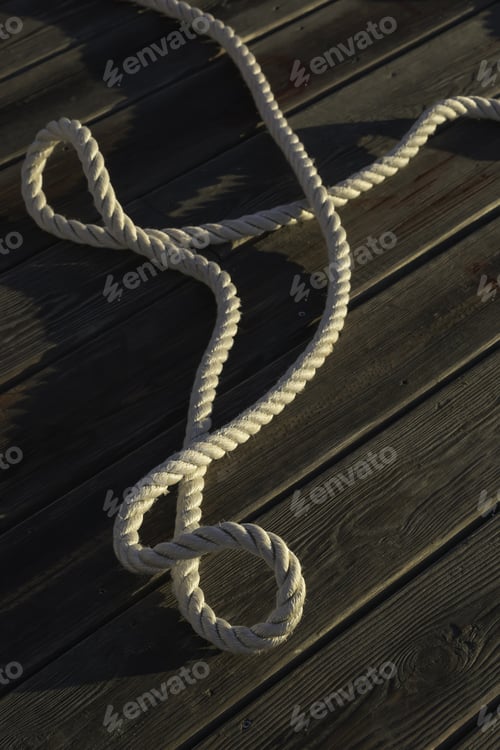 Preview: Nautical Laxity: Long Twist Of Thick Rope On Wooden Pier At Sunrise (Selective Focus)