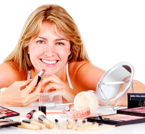 Preview: Woman Applying Lipstick at Vanity Table with Makeup