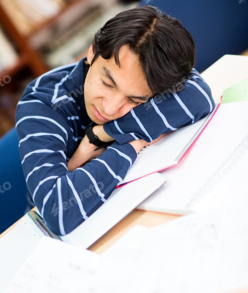 Preview: Tired Male Student Sleeping On A Pile Of Books