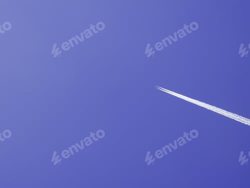 Preview: Commercial Jetliner Flying High, With White Contrails, In Blue Afternoon Sky
