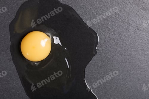 Preview: Raw Egg Poured Onto Black Slate
