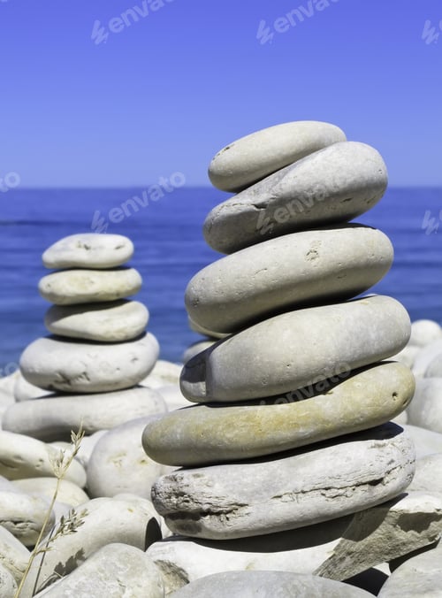 Preview: Vertical Piles Of Smooth Beach Rocks By Blue Lake And Sky (Selective Focus)