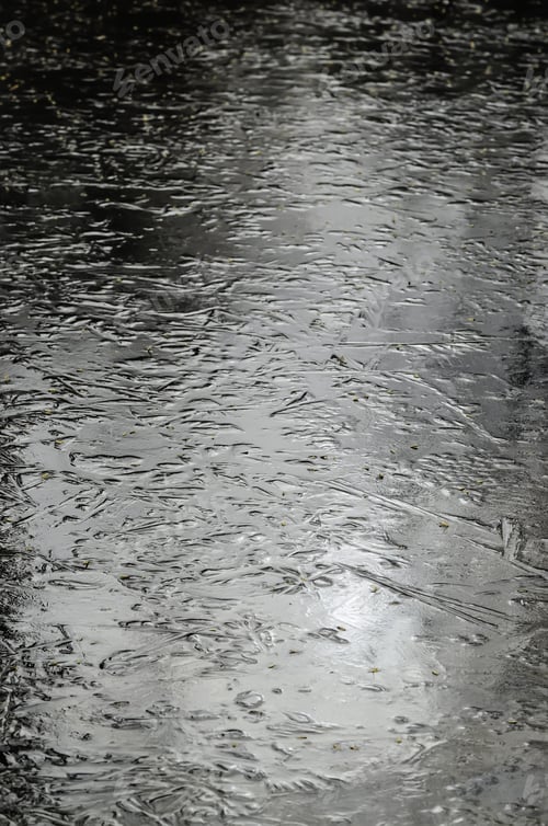 Preview: Frozen Surface Of Stream -- With "Footprints" Of Leaves And Branches From Surrounding Woods