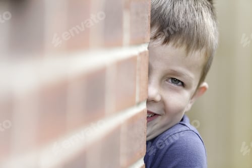 Vorschau: Lächelnder Junge beim Versteckspiel