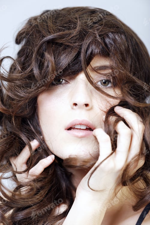 Preview: Beautiful Young Woman'S Face With Long Curly Dark Hair Expressing Mood
