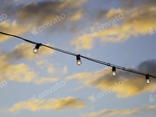 Preview: Part Of A String Of Bare Tungsten Light Bulbs Shining On A Cruise Ship At Sunset